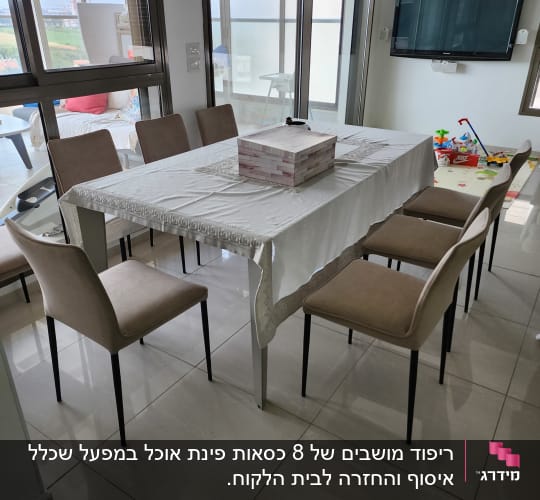 שולחן אוכל עם מפה לבנה וכיסאות מרופדים